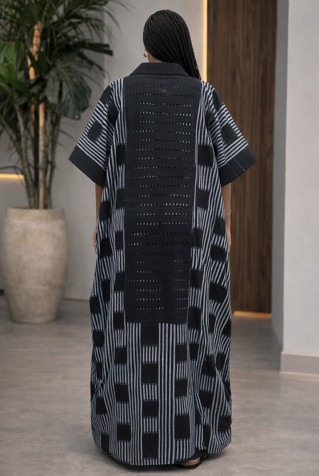 Person wearing a black and white patterned dress in an indoor setting.