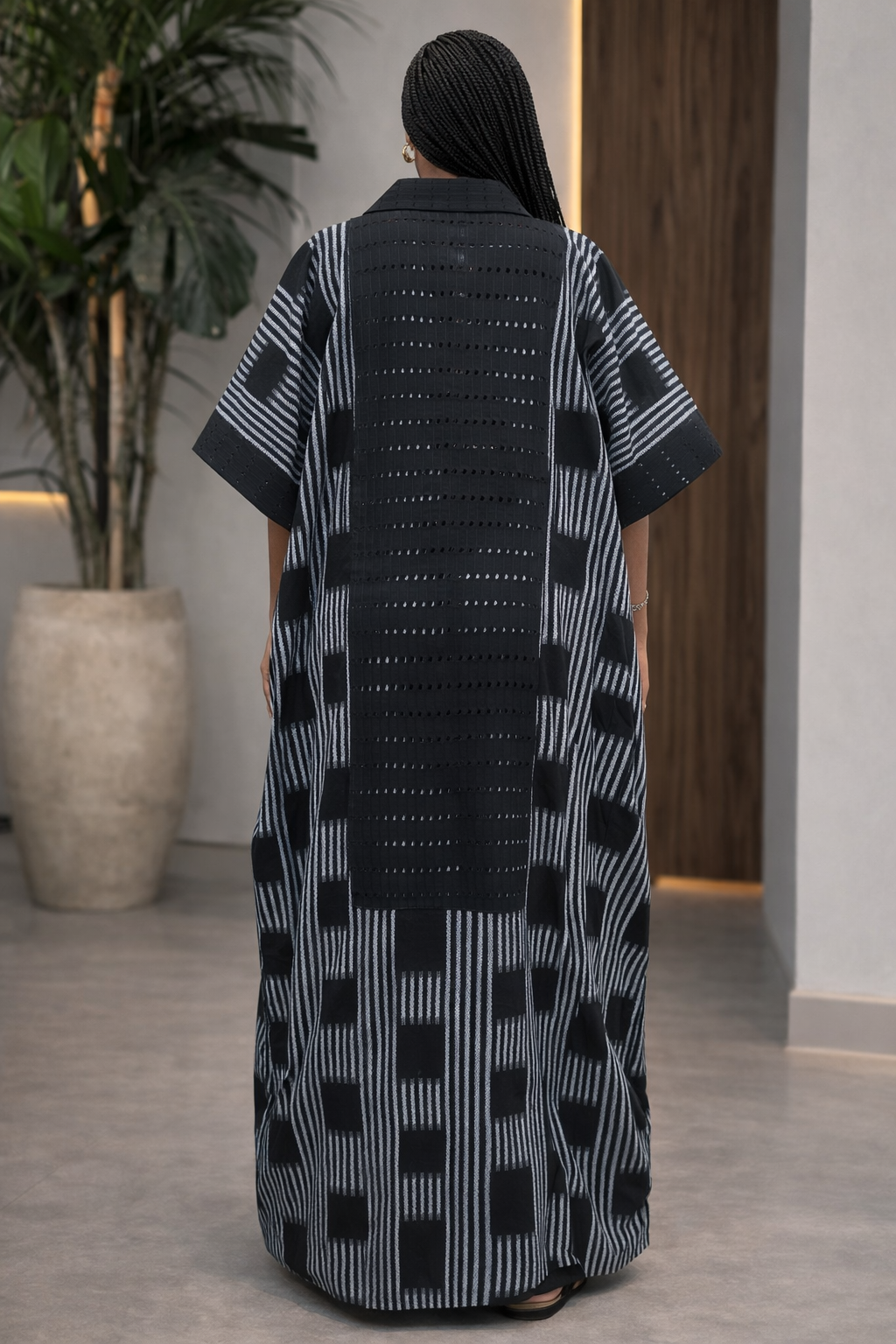 Person wearing a black and white patterned dress in an indoor setting.