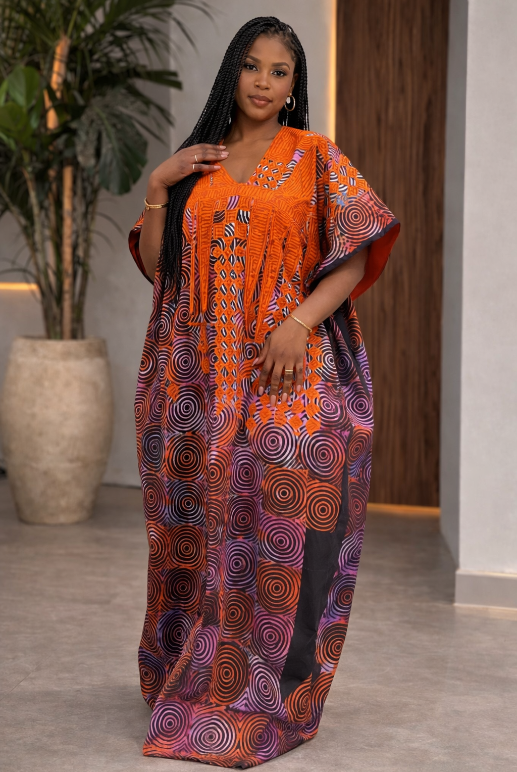 Woman wearing an orange and purple patterned dress indoors.