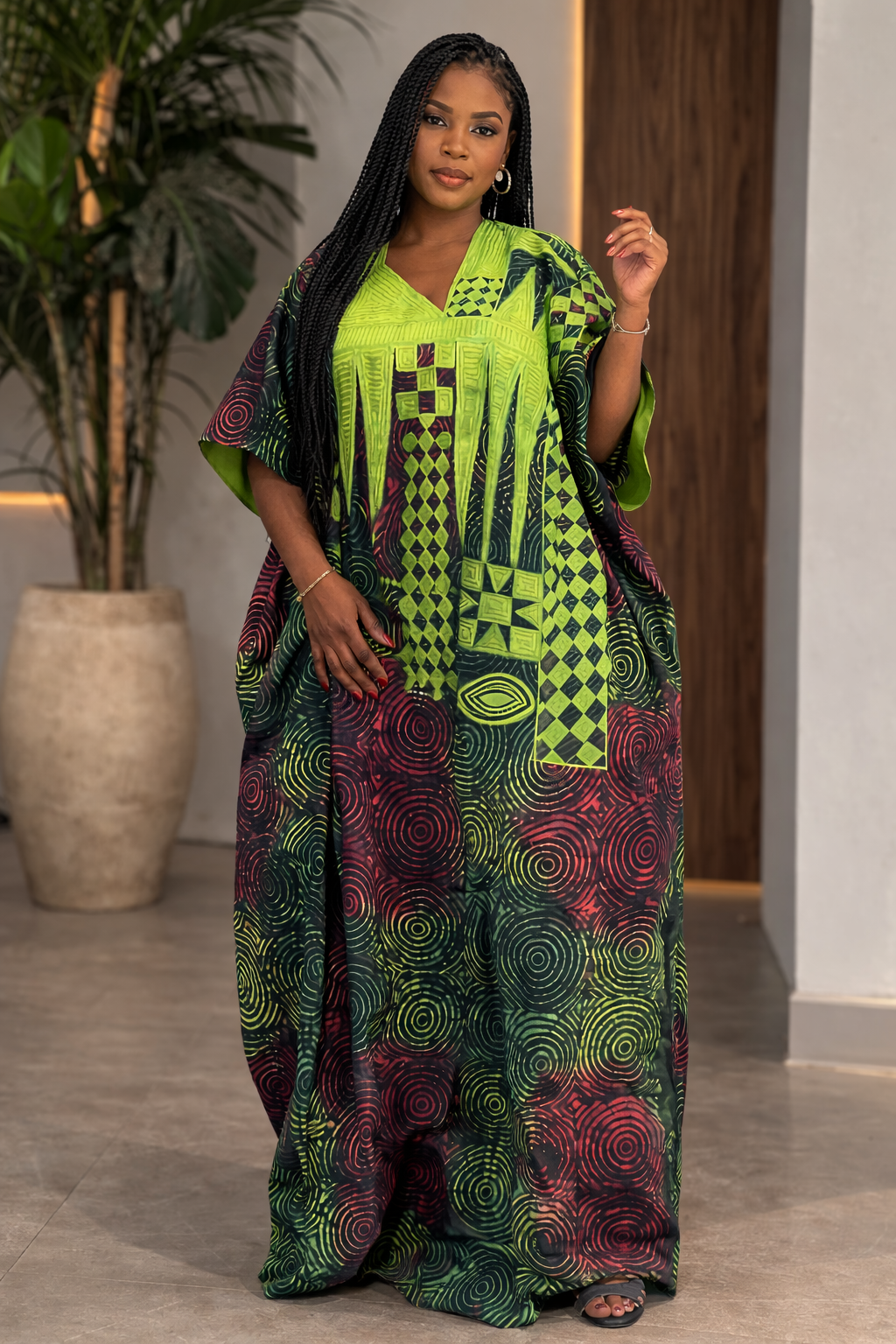 Woman wearing a vibrant, patterned outfit indoors with a plant in the background