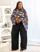 Woman wearing a colorful patterned coat in a modern interior setting