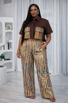 Woman wearing a brown shirt and striped pants in a room with white curtains.
