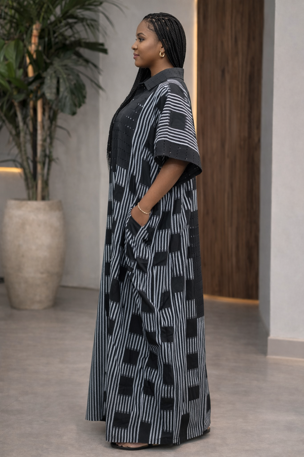 Woman wearing a black and white patterned dress standing indoors.